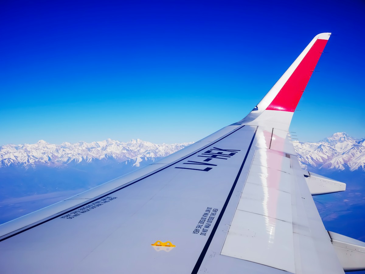 An airplane wing above the snow-covered Andes